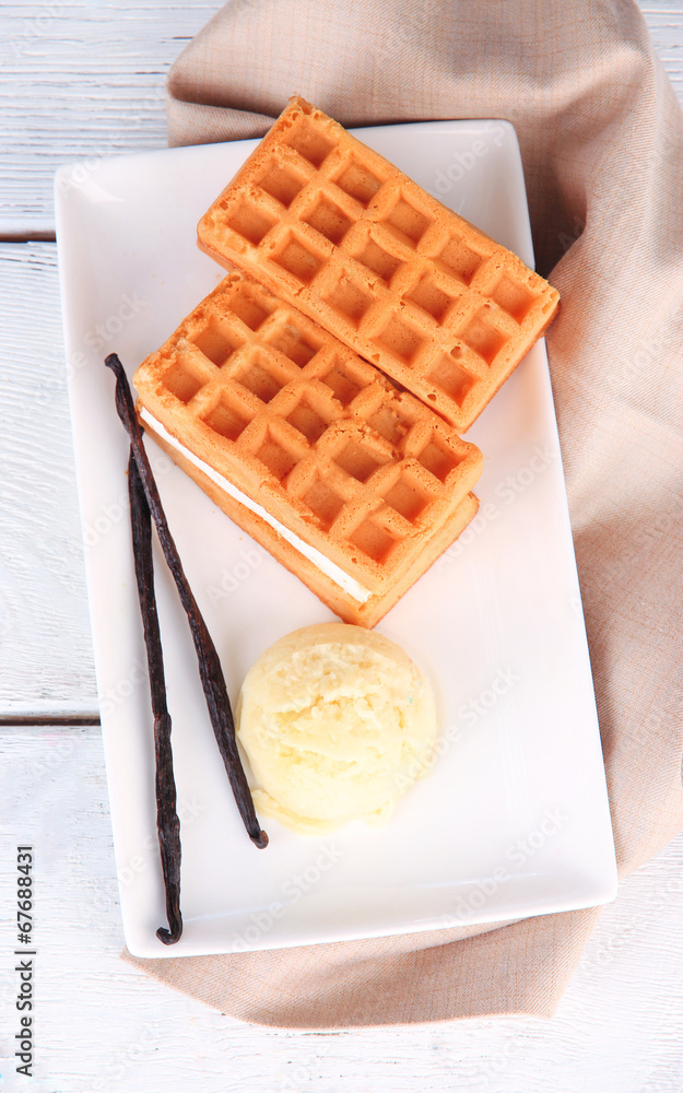 Tasty belgian waffles with ice cream on wooden table