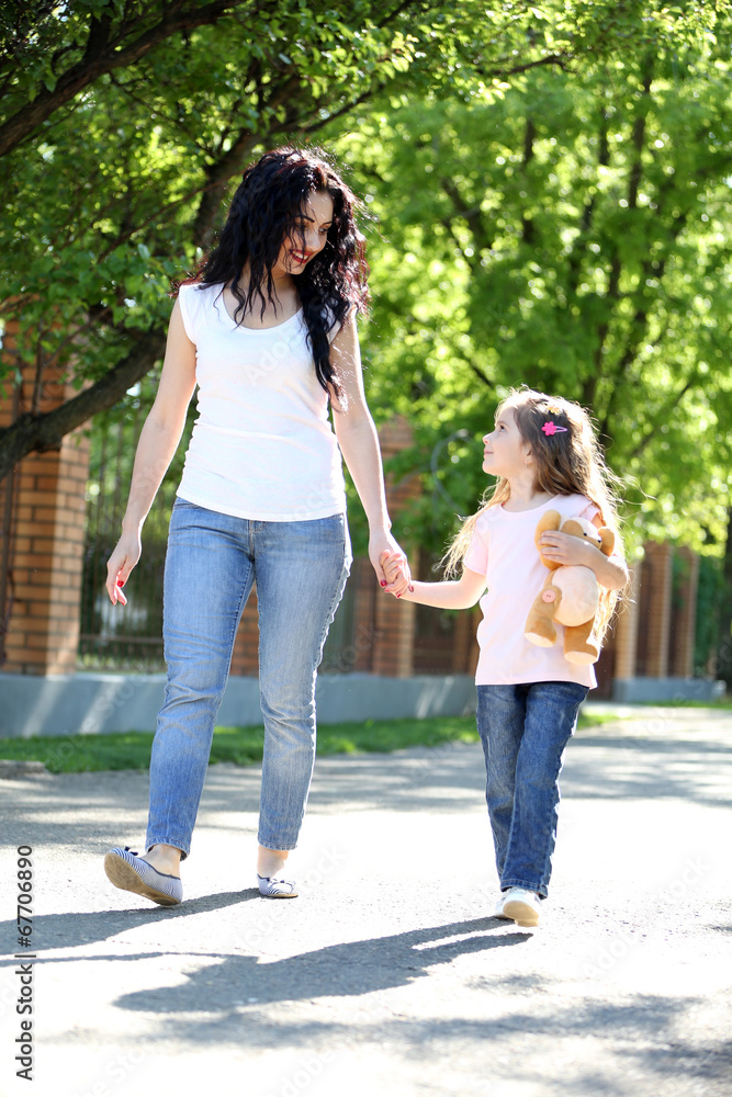 Happy mom and daughter. Walk in the green park