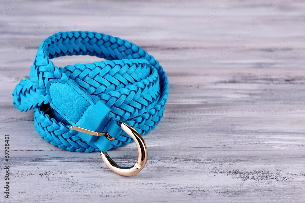 Blue leather belt on wooden background