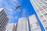 Fototapeta Nowy Jork - Airplane flying in business district sky,motion,blur