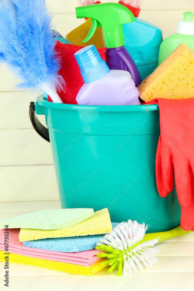 Cleaning items in bucket on  white wooden background