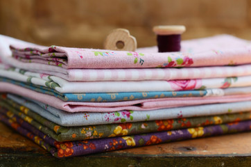 Stack of floral pattern textile and wooden spools
