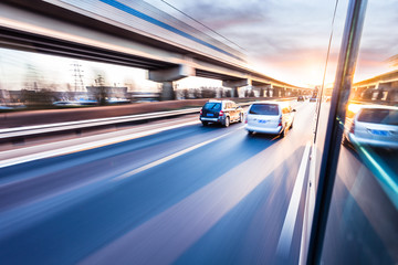 Wall Mural - Car driving on freeway at sunset, motion blur