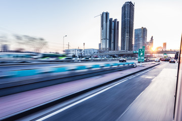 Wall Mural - Car driving on freeway at sunset, motion blur