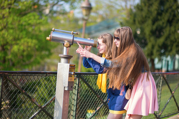 Girls using telescope for sightseeing in Paris