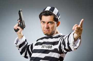 Prisoner with gun against dark background