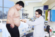 © Creativa Images - Doctor examining a patient obesity 1