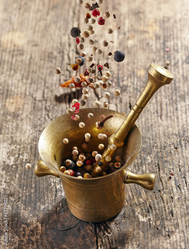 Obraz w ramie various spices falling into mortar and pestle