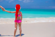 © travnikovstudio - Back view of cute girl in red hat santa claus on the beach