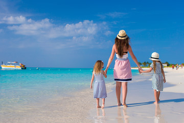 Wall Mural - Back view of mother and little daughters enjoy summer vacation