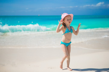 Adorable little girl in hat at beach during caribbean vacation