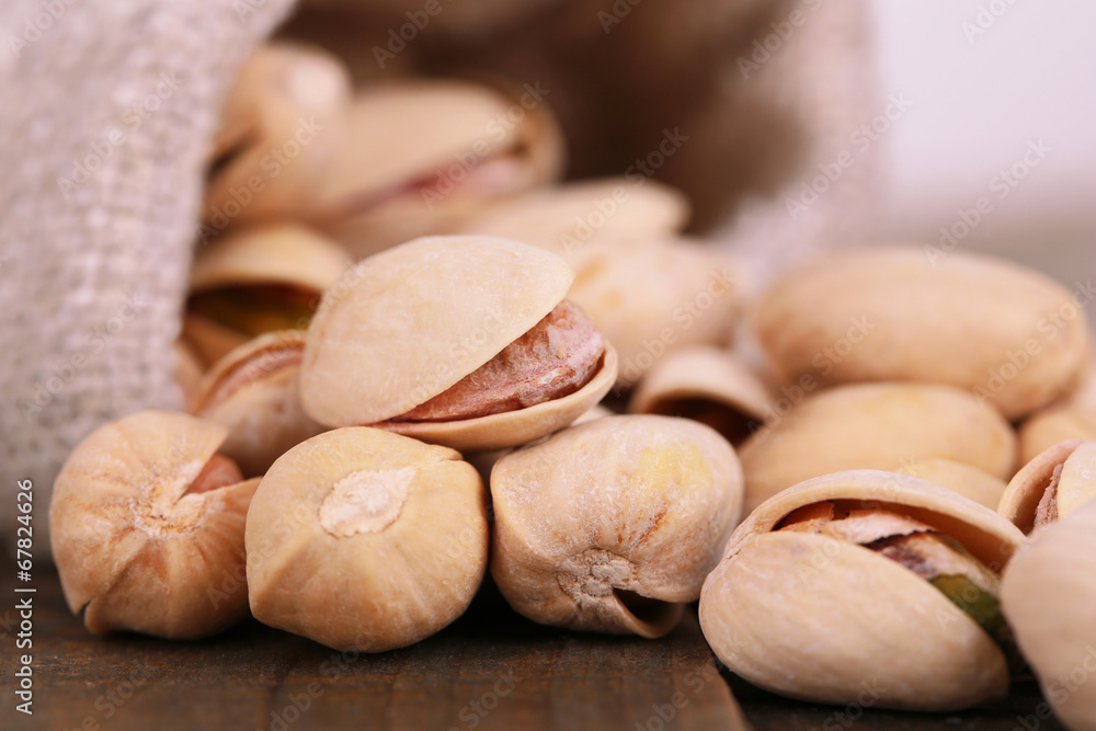 Pistachio nuts in sackcloth bag on table close up