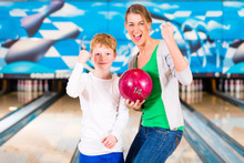 Mother And Son Playing Together At Bowling Center
