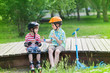 © anrymos - children with rollers and scooter sit on a wooden path