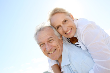 Poster - Senior man giving piggyback ride to wife