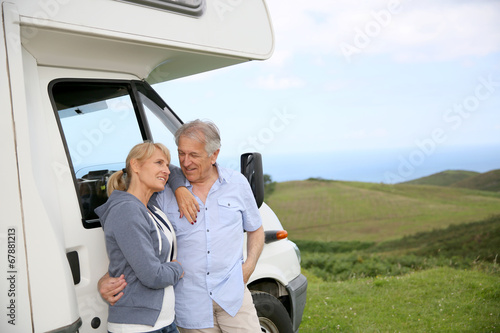 Cuadros en Lienzo Senior couple standing by motorhome in countryside