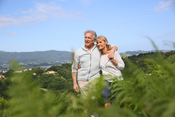 Wall Mural - Senior couple walking in countryside, scenery