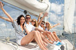 © Syda Productions - smiling friends sitting on yacht deck and greeting