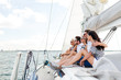 © Syda Productions - smiling friends sitting on yacht deck