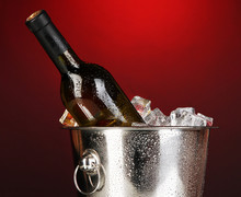 Bottle Of Wine In Ice Bucket On Darck Red Background