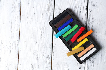 Wall Mural - Colorful chalk pastels in box on wooden background