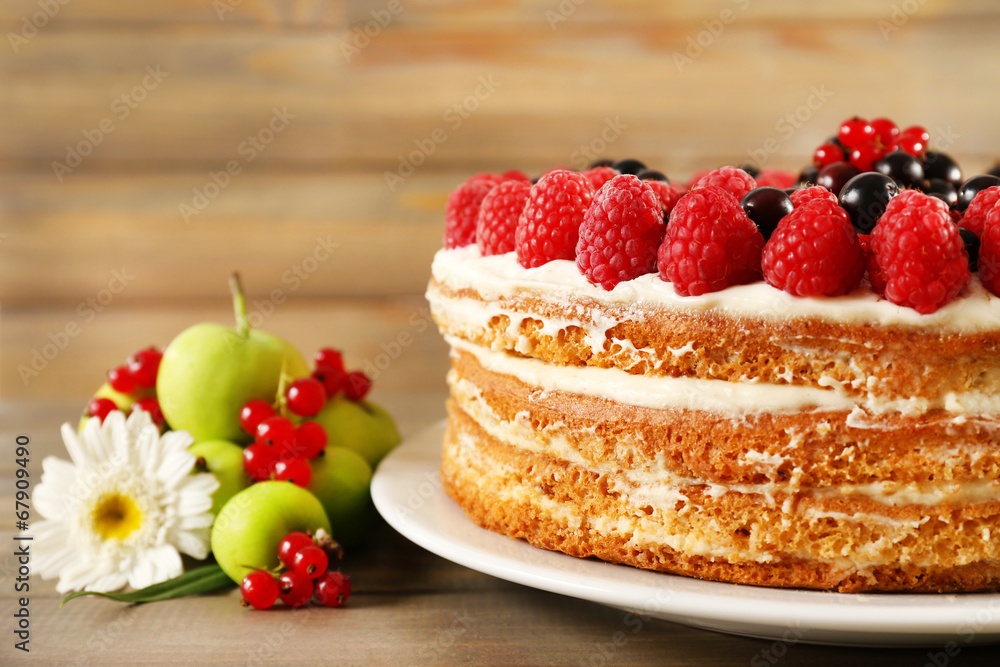 Tasty cake with fresh berries on wooden table