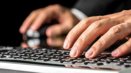 Man typing on a computer keyboard