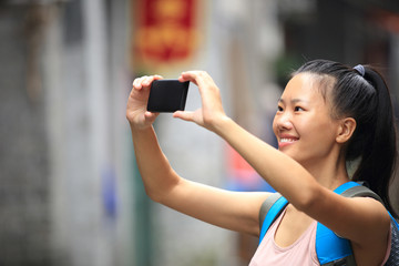 Wall Mural - woman tourist taking photo with smart phone in guilin,china 