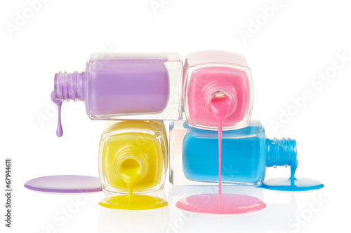 Fotografía Uñas botellas de esmalte derramando aislados en blanco, camino de recortes