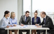 © Syda Productions - business team with documents having discussion