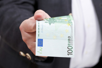 Wall Mural - front view 100 euro banknote in businessman hand