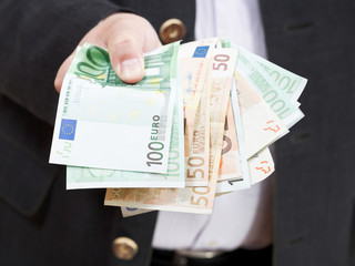 Wall Mural - fanned euro banknotes in male hands