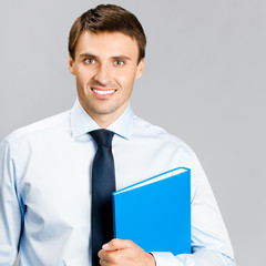 Portrait of business man with folder, over gray