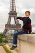 Cheerful teenager shows the Eiffel tower, France