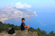 young traveler looks at the beautiful seascape from the mountain