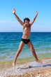 Happy boy jumping on the beach