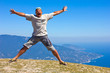 happy man jumping on a background of mountains and sky and sea