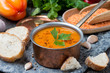 red lentil soup with pepper and spices in a copper saucepan