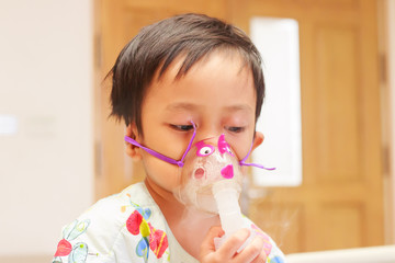 little boy lying in bed with inhalator mask