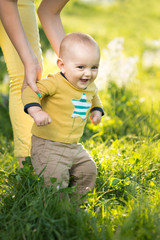 Wall Mural - Mom teaches son walking grass