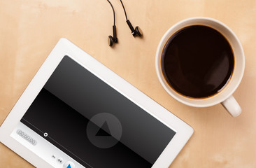 Wall Mural - tablet pc showing media player on screen with a cup of coffee on