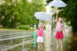 © MNStudio - Two cute little sisters having fun under a rain