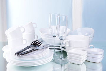 Poster - Set of white dishes on table on light background