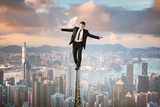 Fototapeta  - businessman in equilibrium on wire upon the city