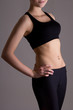 © Di Studio - slim woman's body in sports wear over grey