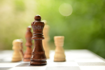 Chess board with chess pieces on bright background