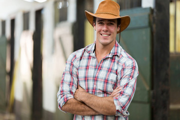 cowboy with arms crossed in stable