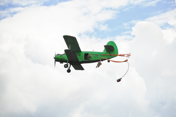 Wall Mural - parachuting jump from small green aircraft