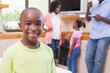 © WavebreakMediaMicro - Cute little boy smiling at camera with family in background