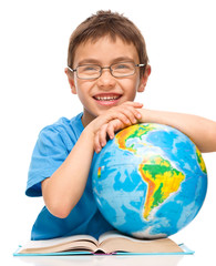 Wall Mural - Little boy is examining globe